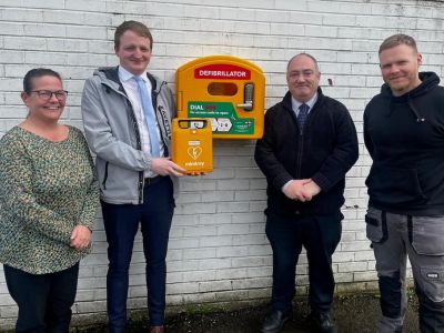 Graham Hart team members holding the defibrillator